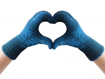 Two hands in blue winter gloves making a heart shape