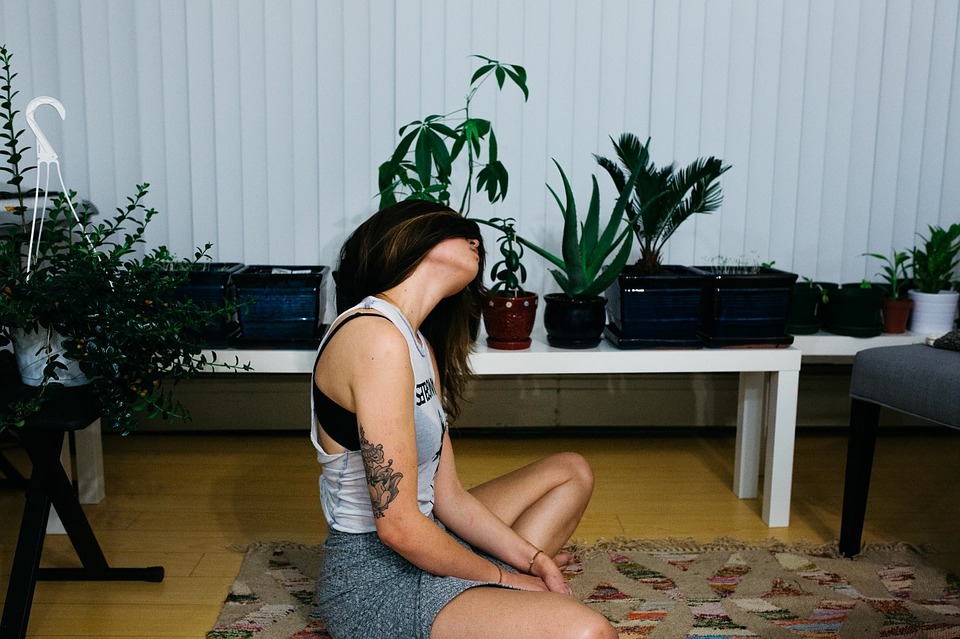 Woman doing yoga surrounded by plants